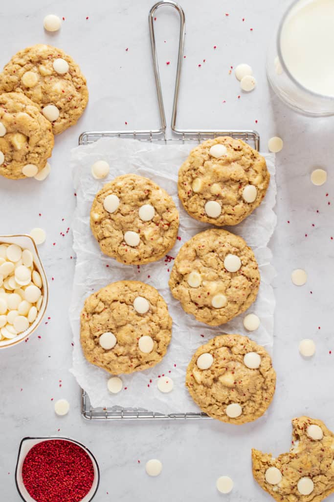 White Chocolate Cranberry Oatmeal Cookies with a glass of milk and bowl of cranberry seeds