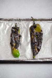 roasted anaheim chiles on a baking sheet