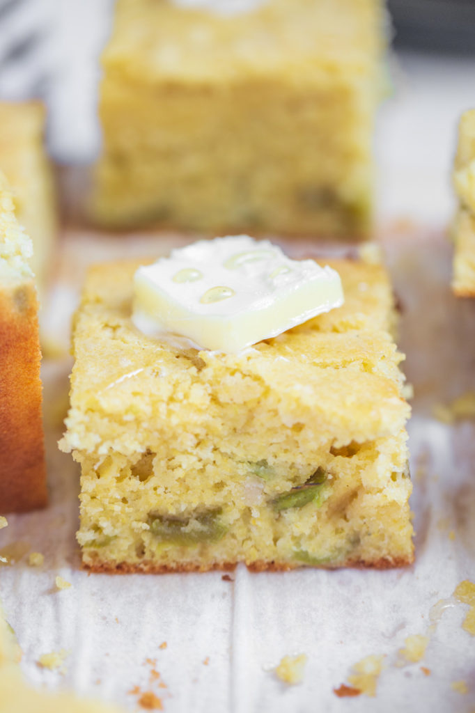 single piece of roasted green chile cornbread with a pad of butter on top